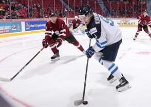 MONTREAL, CANADA - JANUARY 2: Finland's Janne Kuokkanen #9 plays the puck while Latvia's Tomass Zeile #15 defends during relegation round action at the 2017 IIHF World Junior Championship. (Photo by Andre Ringuette/HHOF-IIHF Images)

